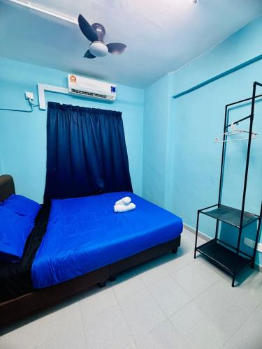 a blue bedroom with a bed and a fan at Charming 2BR for 5pax Convenient malaysian guest only Location by USM in Gelugor