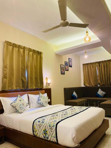 a bedroom with a bed and a ceiling fan at Sitevi Inn & Suites in Kota