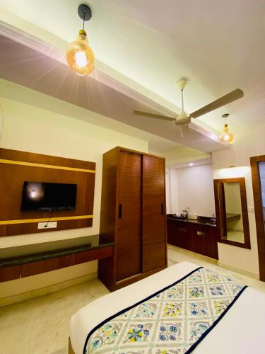 a bedroom with a bed and a flat screen tv at Sitevi Inn & Suites in Kota