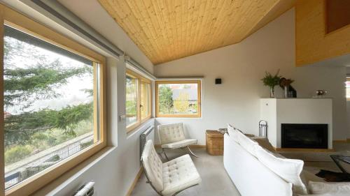 a living room with two chairs and a fireplace at Chalet Serra 1506 Geopark S Estrela in Penhas da Saúde