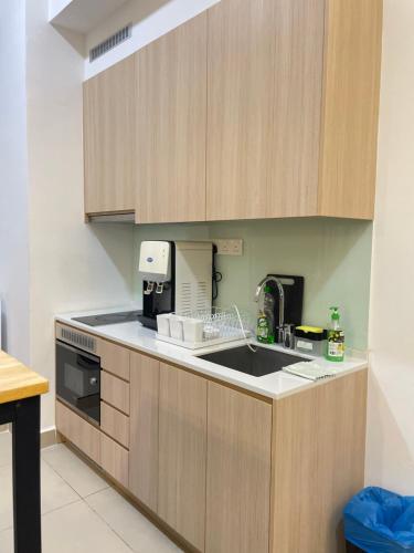 a kitchen with wooden cabinets and a sink at The Luxe KLCC by Homestay in Kuala Lumpur