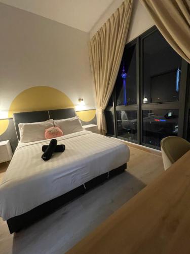 a bedroom with a large bed with a large window at The Luxe KLCC by Homestay in Kuala Lumpur
