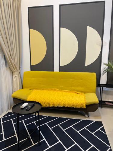 a yellow couch in a living room with a table at The Luxe KLCC by Homestay in Kuala Lumpur