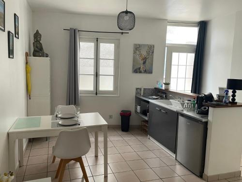 a kitchen with a table and a white counter top at Appartement centre historique Sancerre in Sancerre