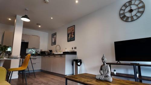 a kitchen and a living room with a clock on the wall at City Center 1 Bed Flat in Peterborough