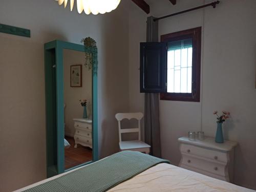 a bedroom with a bed and a mirror and a window at CasaArabí in Arabí