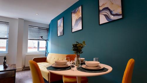 a dining room with a table and a blue wall at City Center 1 Bed Flat in Peterborough