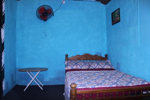 a blue bedroom with a bed and a stool at Munnar Kudil Resto Cafe Family Room in Anaviratty