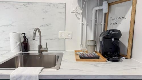 un comptoir de cuisine avec un évier et un mitigeur dans l'établissement Studio Cosy à Deux Pas du Canal, à Paris