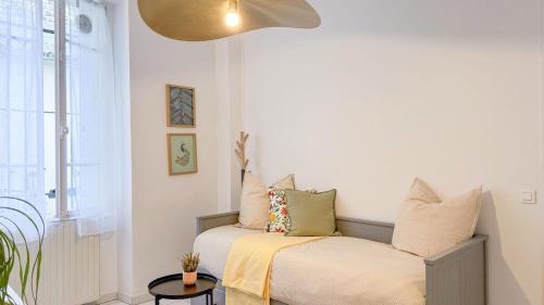 une chambre avec un lit avec des oreillers dessus dans l'établissement Studio Cosy à Deux Pas du Canal, à Paris