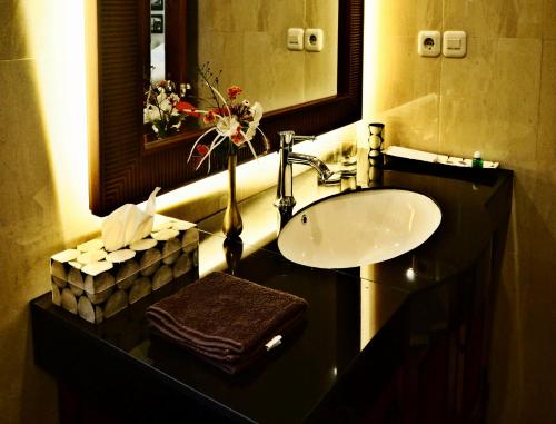 a bathroom with a sink and a mirror at The Gecho Inn Country in Jepara