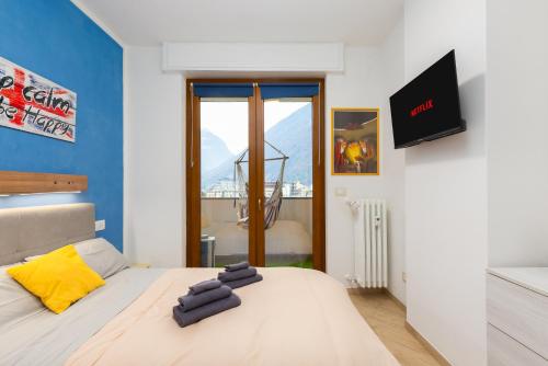a bedroom with a bed with a yellow and blue wall at 1min from Bernina Express - Mountain View - AC - WiFi in Tirano