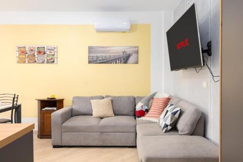 a living room with a couch and a flat screen tv at 1min from Bernina Express - Mountain View - AC - WiFi in Tirano