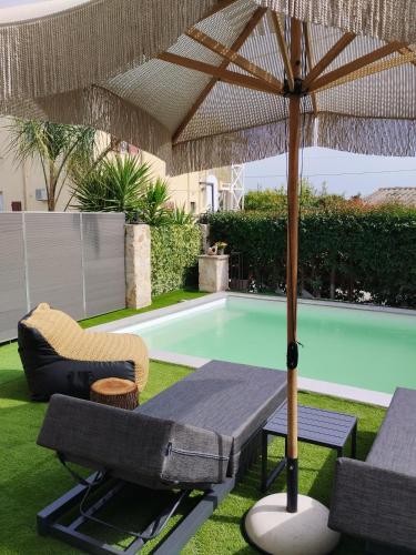 a table with an umbrella next to a swimming pool at Luxury Villas Chrysa Private Pool & Spa in Nafplio