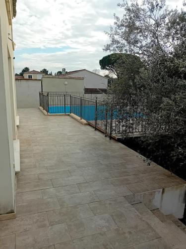 une terrasse avec une clôture à côté d'une maison dans l'établissement Villa Pont du Gard, à Castillon-du-Gard