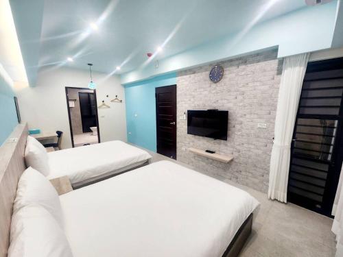 a bedroom with two beds and a brick wall at 別有洞天電梯包棟民宿漢北館 in Taitung City