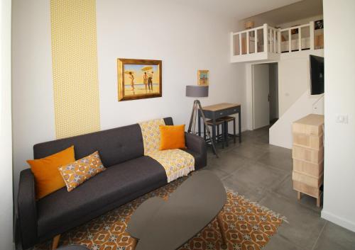 un salon avec un canapé noir et une table dans l'établissement Gioffredo, à Nice