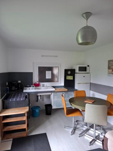 a kitchen with a table and chairs and a sink at Petit cocooning Au cœur de la Sologne in Romorantin