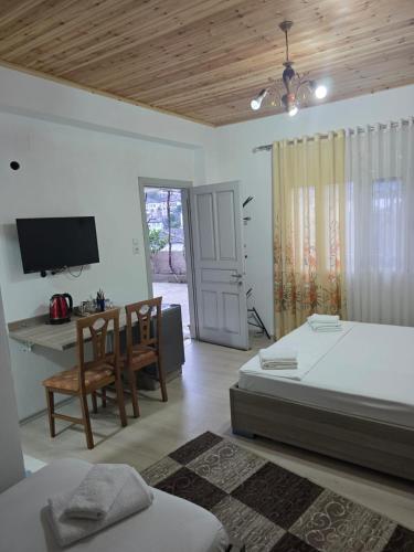 a bedroom with a bed and a desk and a television at Magnolia's Private Room in Gjirokastër