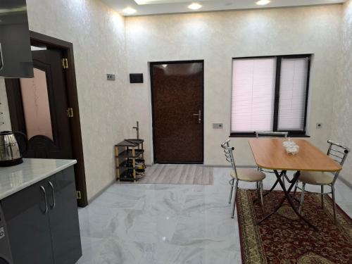 a kitchen and dining room with a table and a door at Ganja VIP Home in Ganja