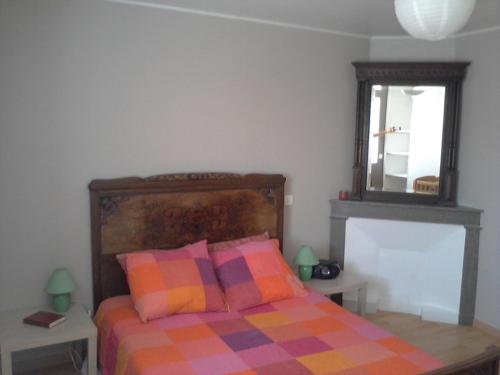 - une chambre avec un lit doté d'oreillers colorés et d'un miroir dans l'établissement Logement Sud Ardèche, à Saint-Sernin