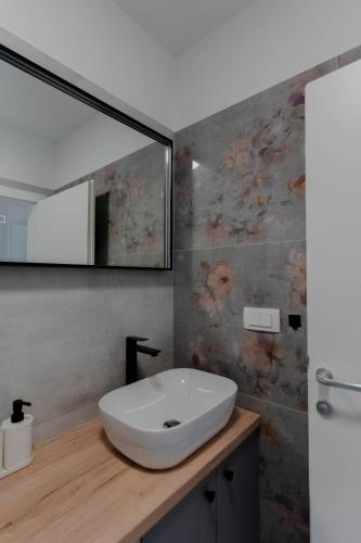 a bathroom with a white sink and a mirror at Villa Azeitona in Sukošan