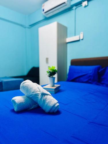 a white towel laying on top of a blue bed at Affordable 3BR for 8 pax Malaysian guest only Walk to Usm Netflix in Gelugor