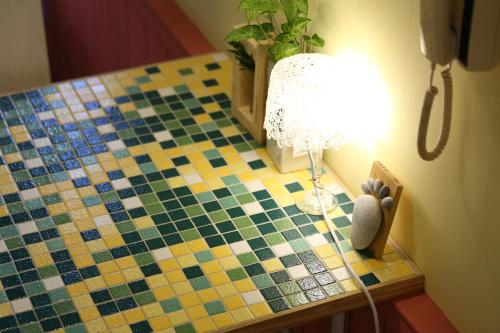 a table with a tiled floor with a lamp on it at Huxi B&B in Jian