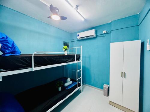a room with two bunk beds and a blue wall at Affordable 3BR for 8 pax Malaysian guest only Walk to Usm Netflix in Gelugor