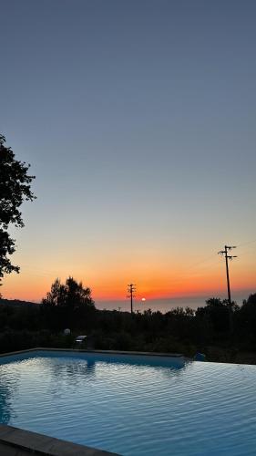 a swimming pool with a sunset in the background at Villa Grazia in SantʼAgata di Militello