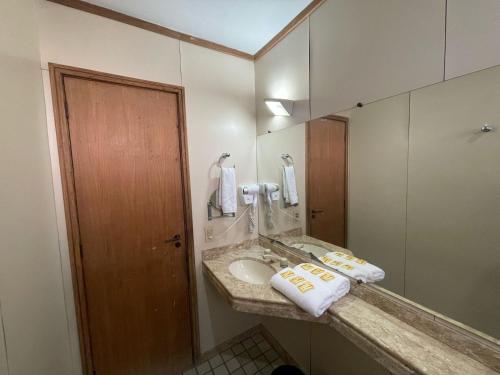 een badkamer met een wastafel en een spiegel bij Apart Hotel Guinard 1403 - Elegante e Acolhedor in Belo Horizonte