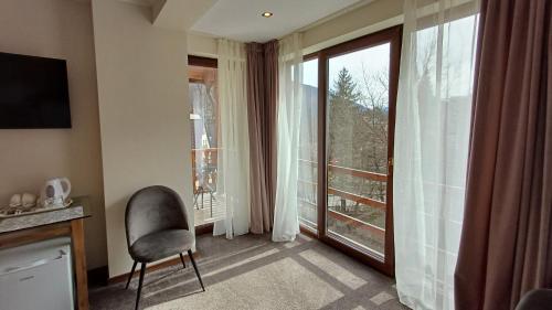 a room with a chair and a large window at Nobila in Sinaia
