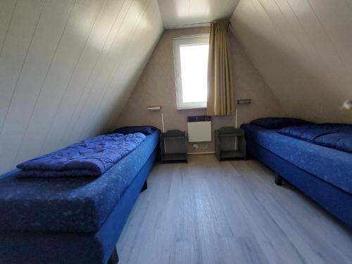a room with two blue beds in a attic at De Gouwe, 158 - aan visvijver, de beste visstek in Gramsbergen
