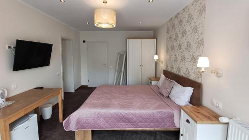 a bedroom with a bed with a pink blanket at Nobila in Sinaia