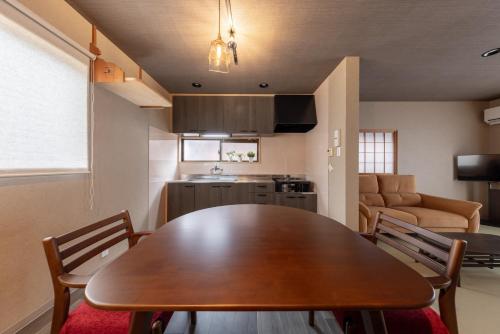 a kitchen and dining room with a wooden table and chairs at NARU Kanazawa in Kanazawa