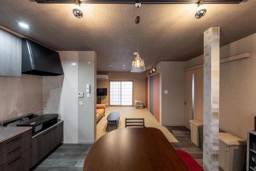 a kitchen and living room with a large wooden table at NARU Kanazawa in Kanazawa
