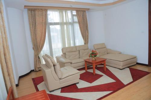 a living room with two chairs and a table at Central Jimma Hotel in Jīma