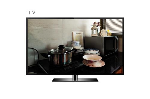a tv screen with a pot and a cup of coffee at Miri Homie1-Grd Flr 3 Rooms 12 Pax in Miri