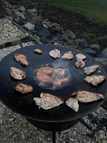 a bunch of meat cooking on a grill at Belezúg-Lak vendégház in Nekézseny