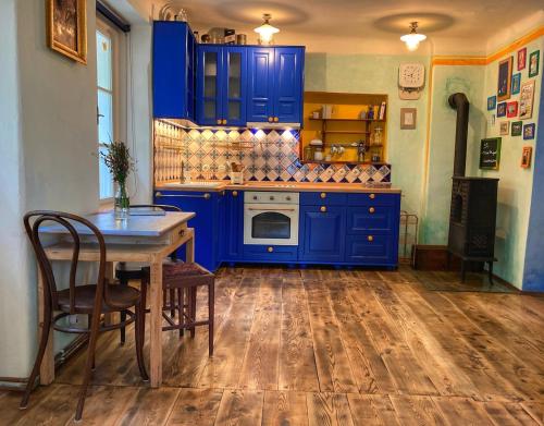 a blue kitchen with a table and blue cabinets at Casa Mexico in Roztoky
