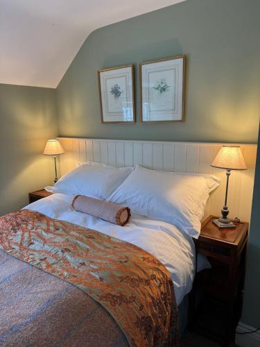 a bedroom with a large bed with two lamps on tables at Woodward Farm House in Appleton le Moors