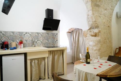a kitchen with a table with a bottle of wine at Dimora Antica Falegnameria - tra STORIA e RELAX in Ostuni
