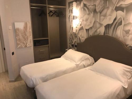 two beds in a hotel room with a mural at Hotel Moderno in Pavia