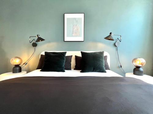 a bedroom with a bed with two lamps on it at Boutique Apartment im charmanten Altbau in Lübeck