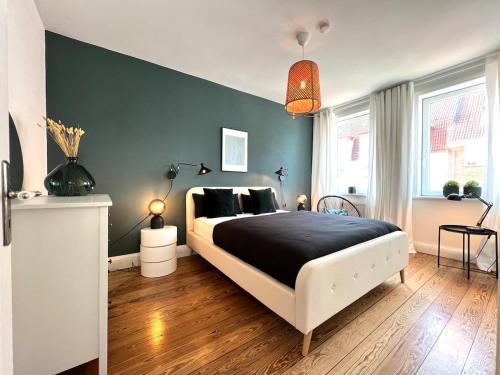 a bedroom with a large bed with a black blanket at Boutique Apartment im charmanten Altbau in Lübeck