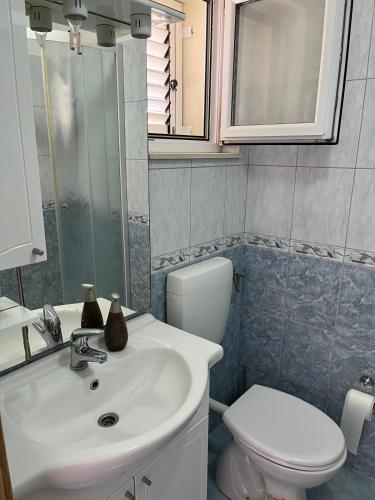 a bathroom with a white sink and a toilet at Apartments Vido in Vodice