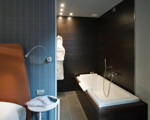 a bathroom with a bath tub and a sink at Hotel Moderno in Pavia