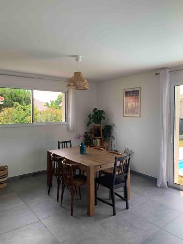 une salle à manger avec une table et des chaises en bois dans l'établissement Vacation home with a pool in a perfect location, à Carcans