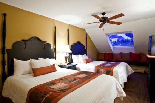 Enjoy snowball fights or romantic nights in a 1BD vacation apartment في Brownsville: غرفة فندقية بسريرين ومروحة سقف