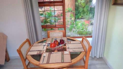 a table and chairs with a bowl of fruit on it at Armadale Country Retreat in Gqeberha